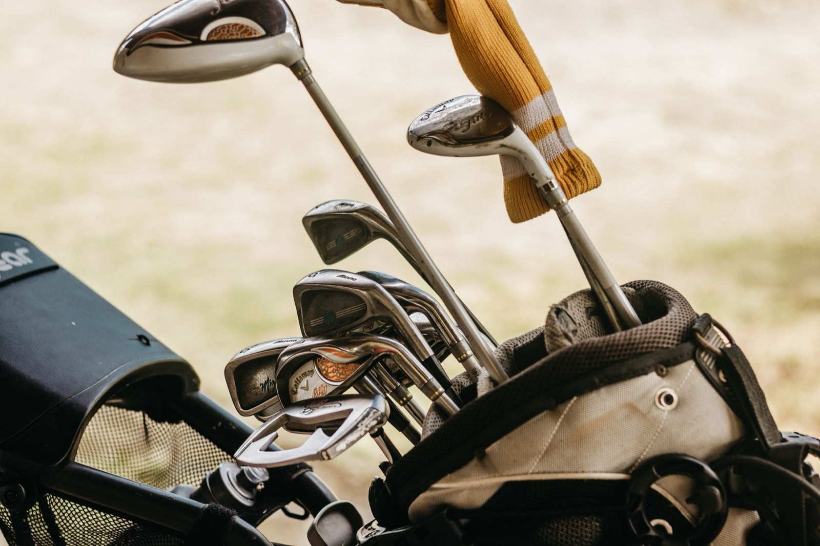 A real golf bag with clubs on a course